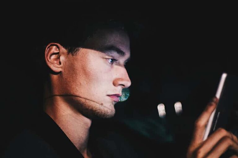 man texting on phone during night