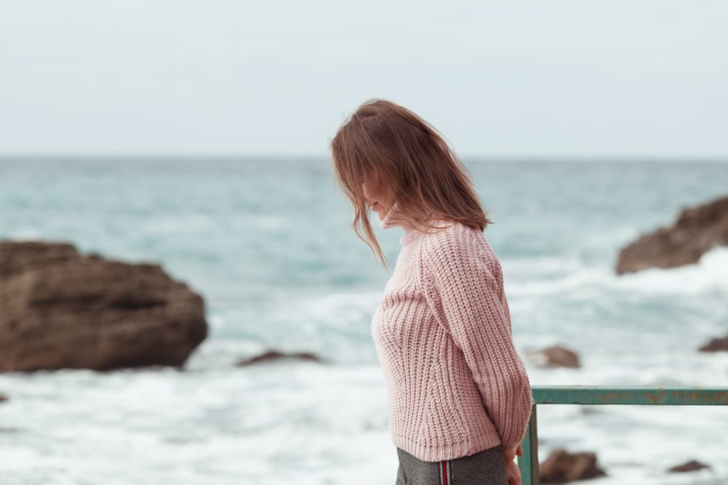 una ragazza triste cammina in riva al mare