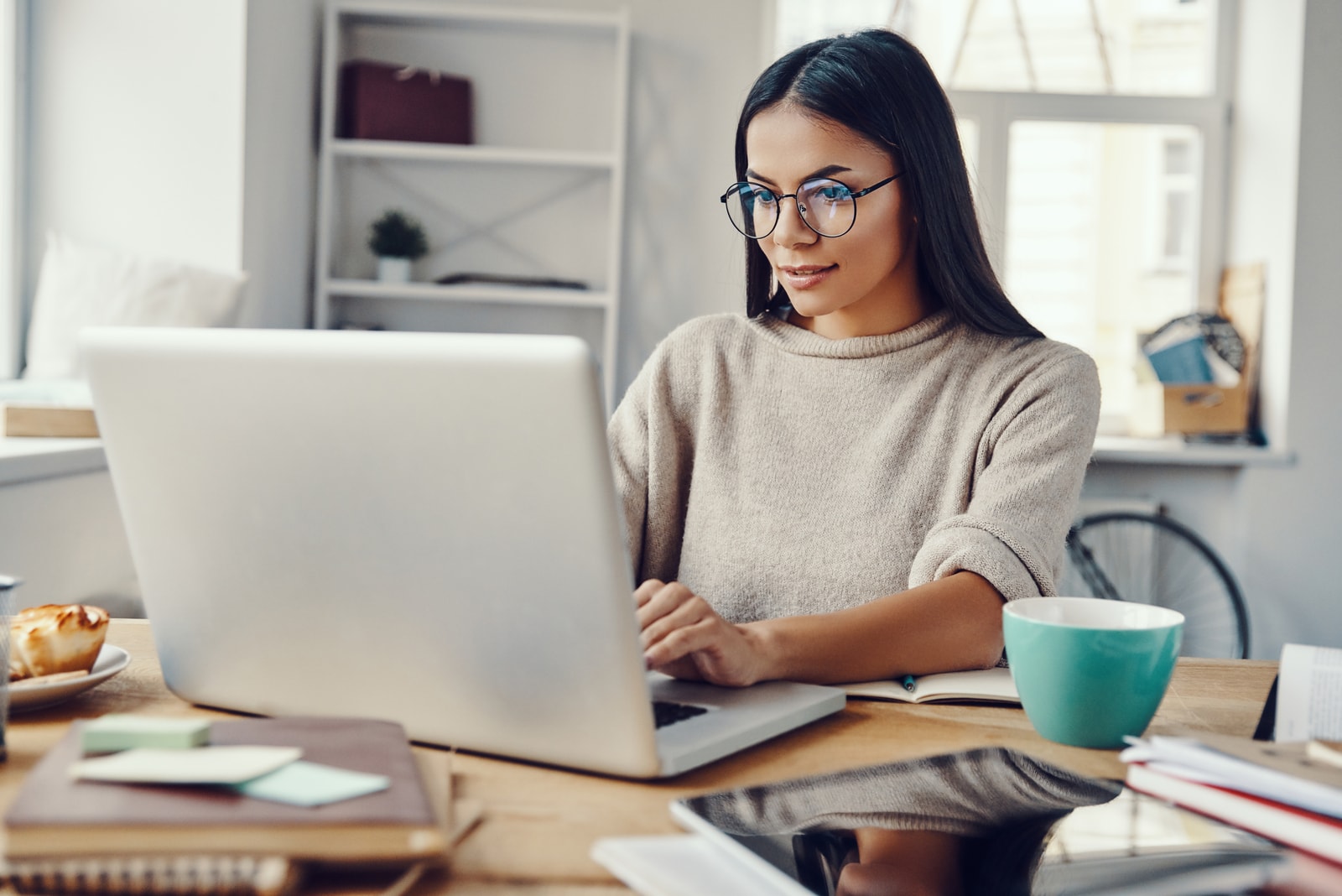 a woman sits at a laptop and works