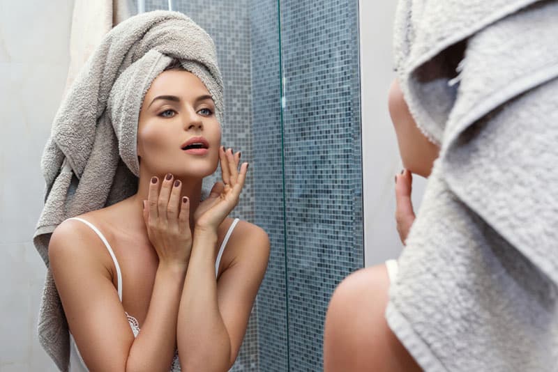 attractive young woman looking at mirror