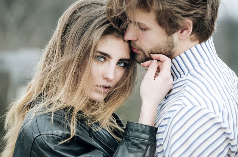 beautiful woman standing with man and looking at camera