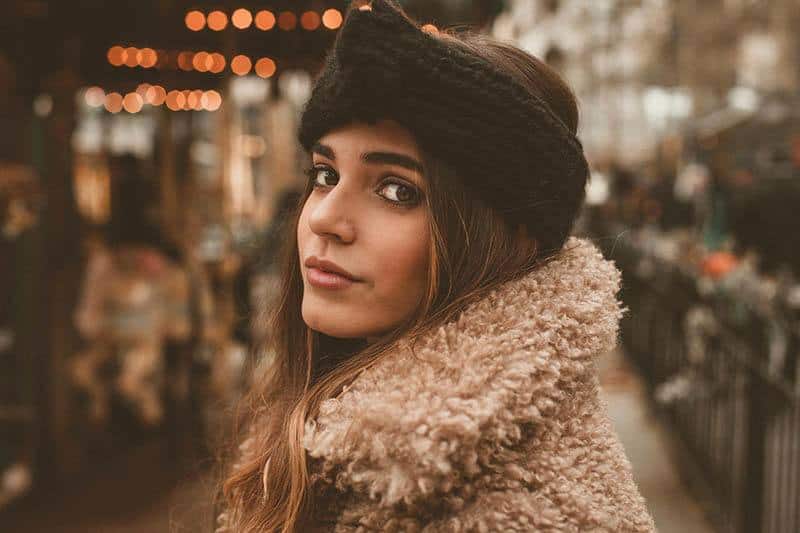 hermosa joven morena con sombrero y chaqueta marrón exterior