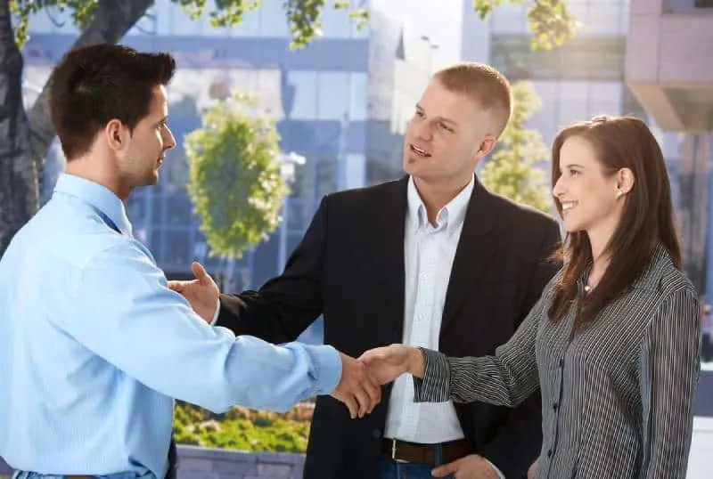 business people meeting outside, man introducing woman to his colleague