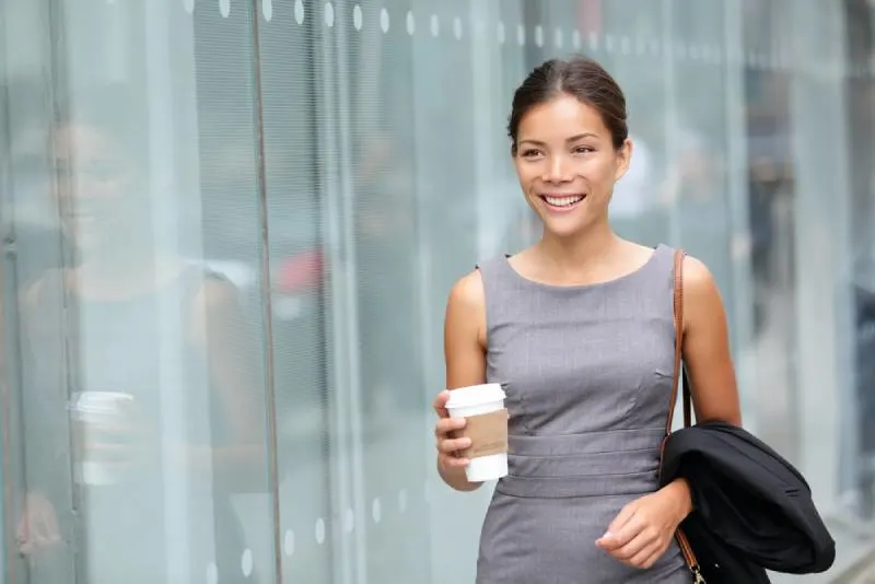 business woman walking and drinking coffee