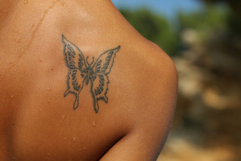 tatuaggio farfalla su schiena femminile