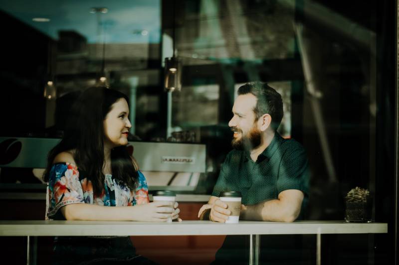 couple drinking coffee and talking in a cafe