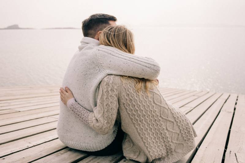 couple hugging in front of lake