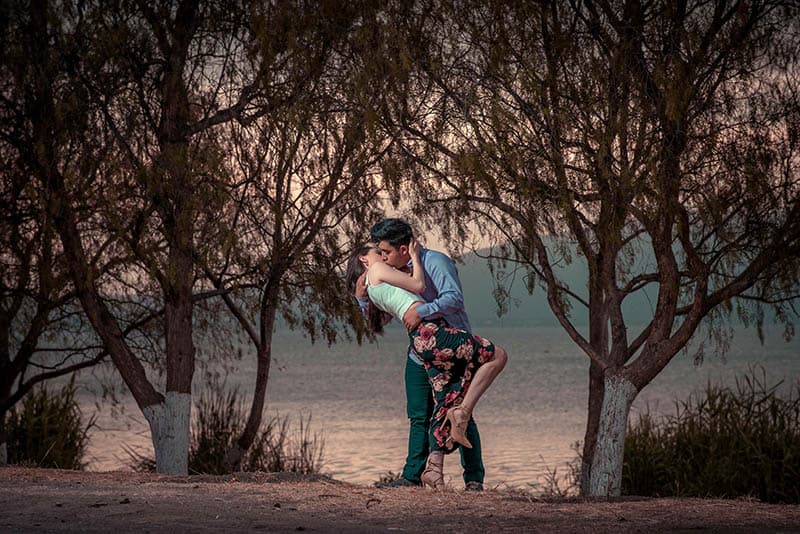 pareja se besa frente al lago