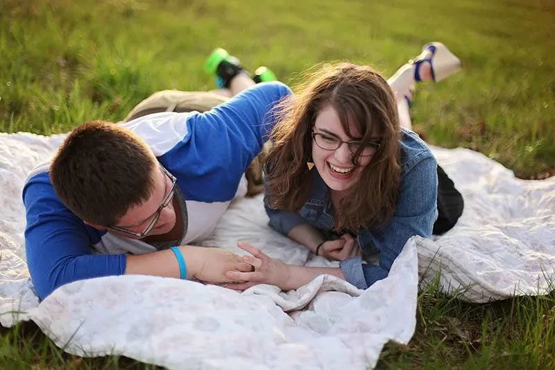 couple lying on grass field and laughing