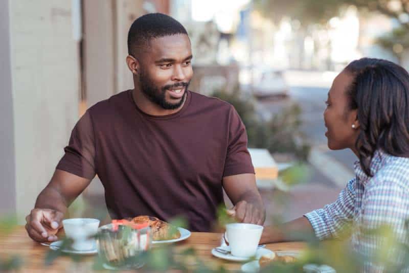 casal a conversar à porta de um café