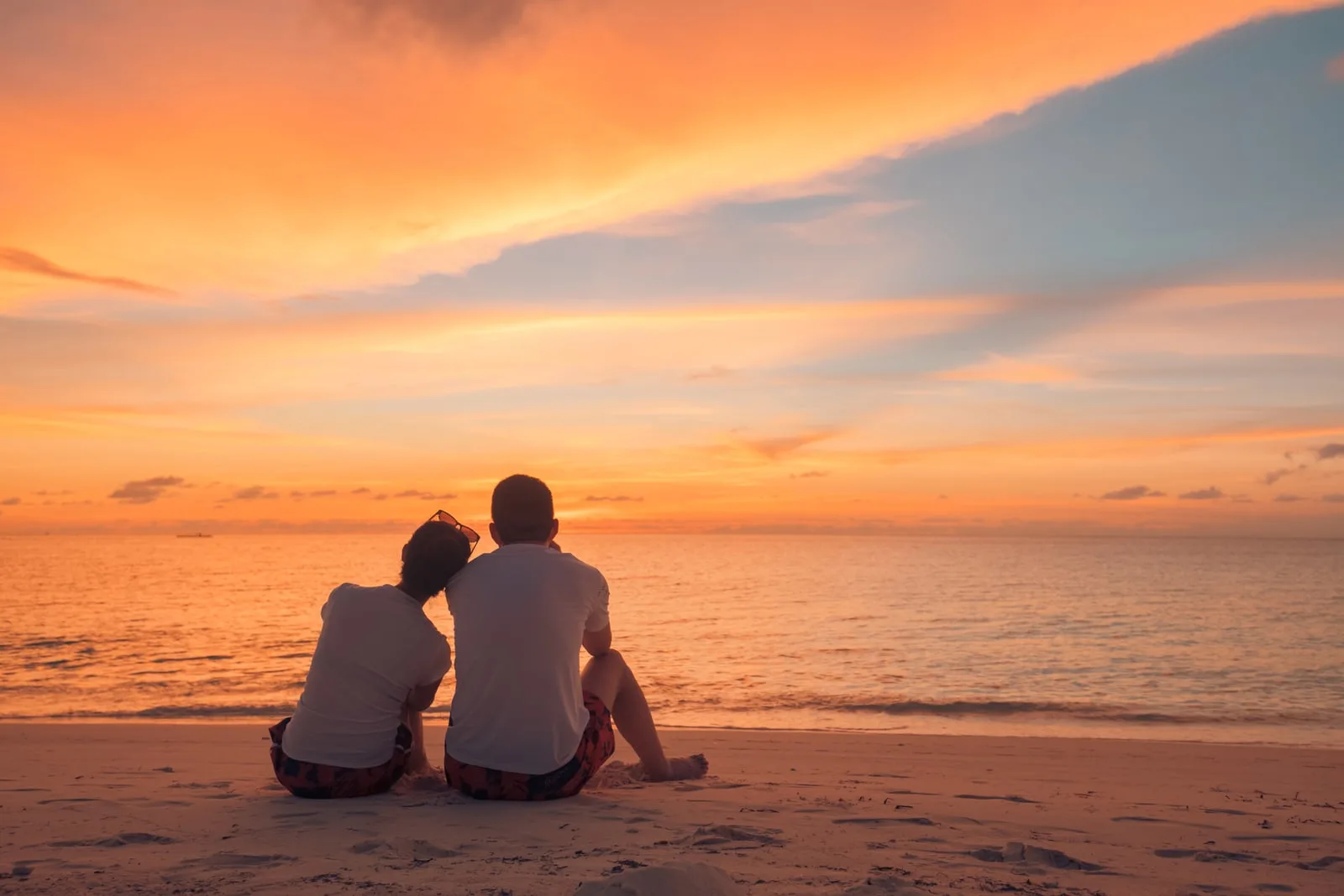 couple watching sunset together on beach