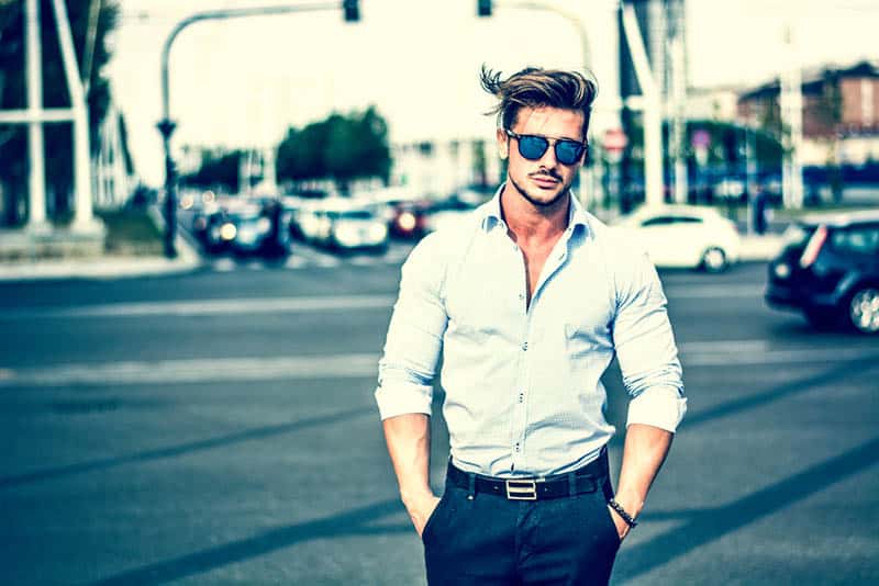 uomo alla moda con occhiali da sole e camicia bianca in strada