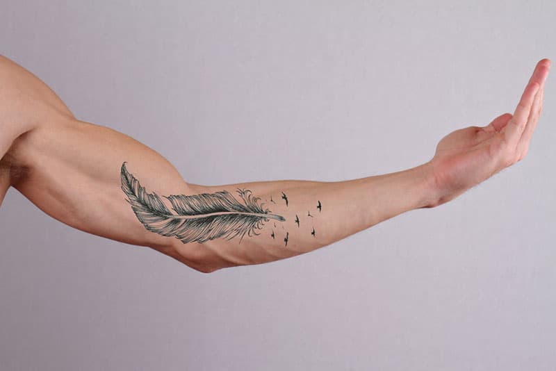 tatuaggio con piuma su mano maschile