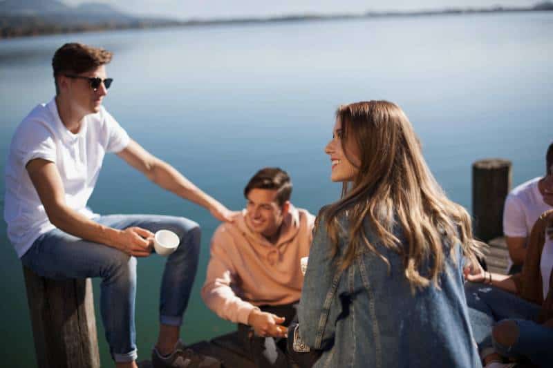 group of friends sitting on a boat dock