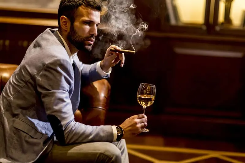 handsome man smoking and drinking whiskey