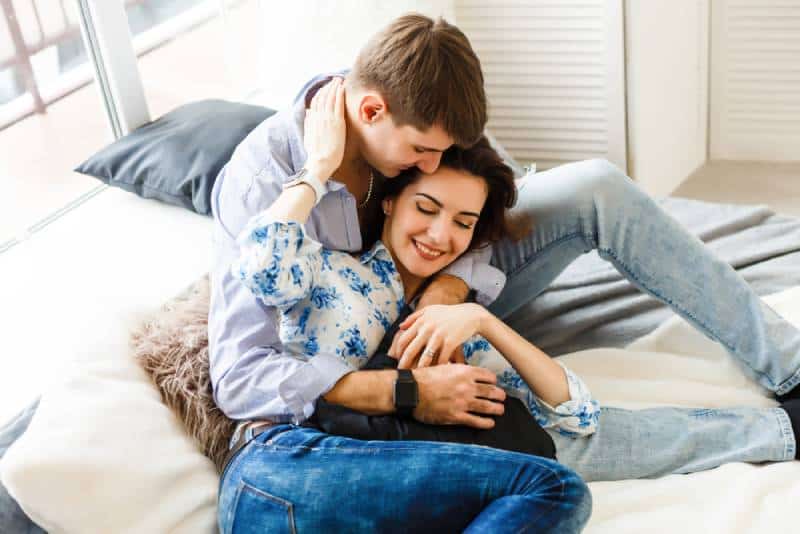 happy couple sitting on sofa at home