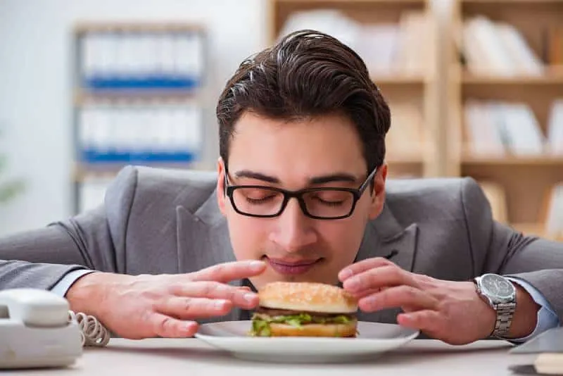 hungry businessman eating sandwich