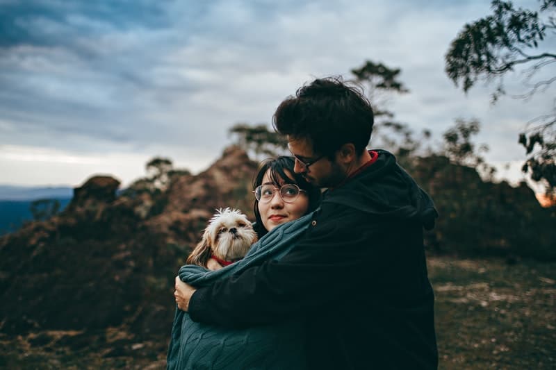 bella coppia che abbraccia e tiene in braccio un cane