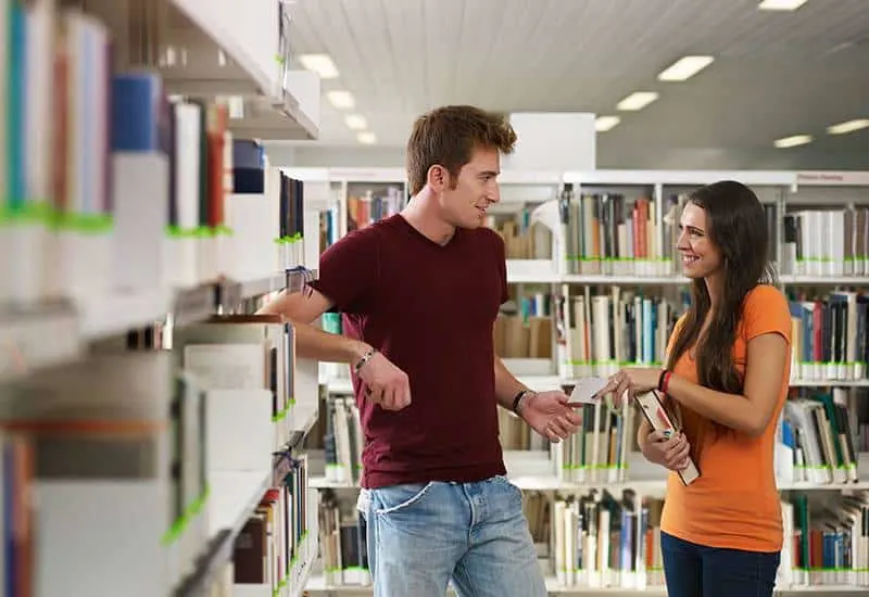 man and woman talking at library