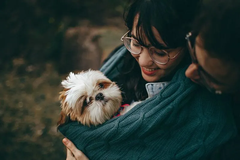 man and woman with cute dog in their arm