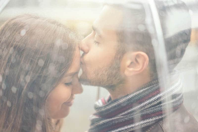  el hombre besa la frente de la mujer linda