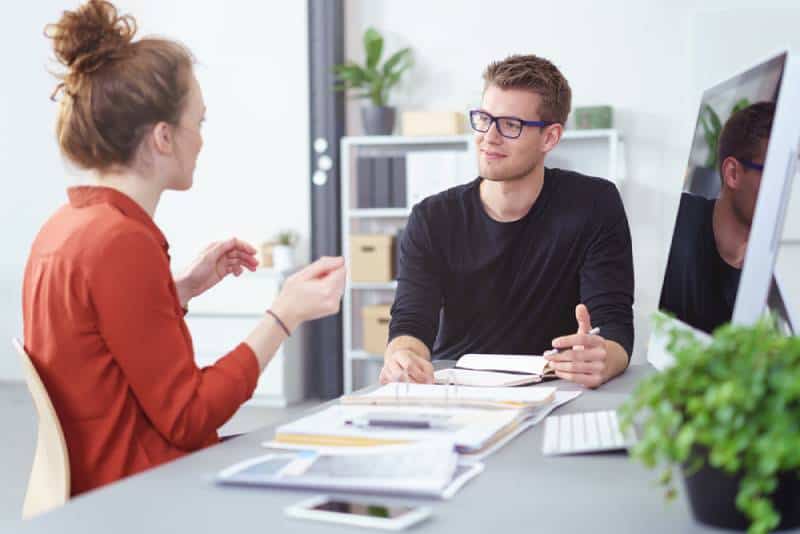 man talking to girl at office desk