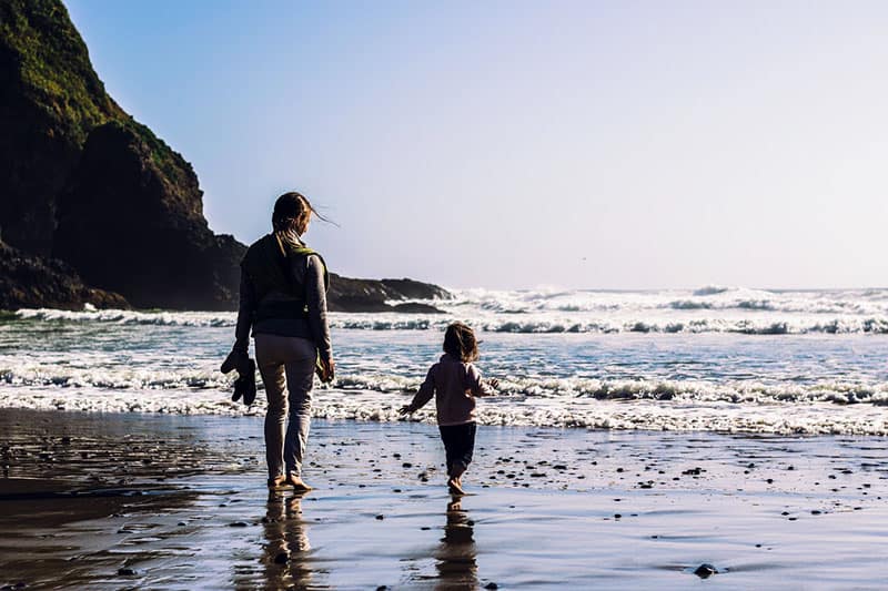 mãe a passear na praia com a sua filha