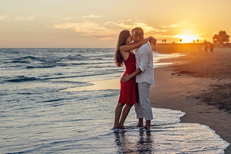 Coppia romantica che si bacia sulla spiaggia