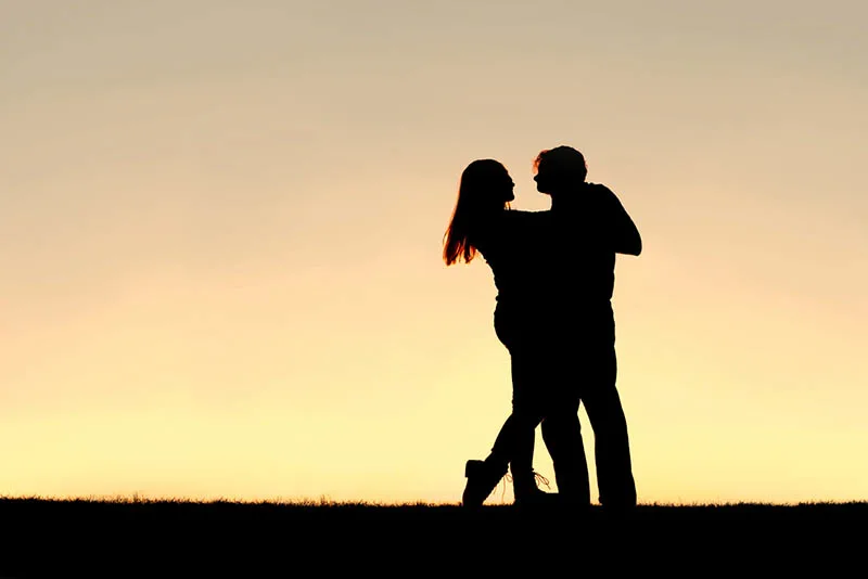 silhouette of couple dancing outside