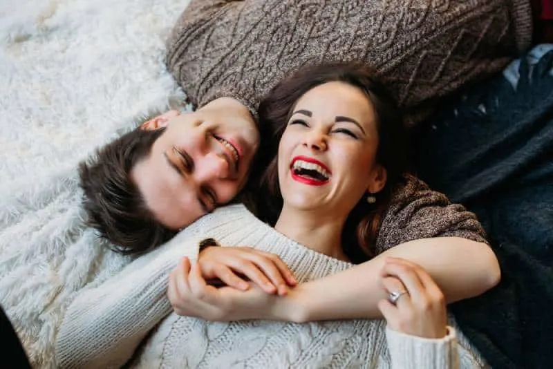 smiling couple lying on floor