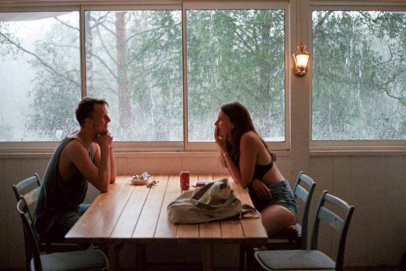 glimlachende man en vrouw die elkaar aankijken terwijl ze aan tafel zitten