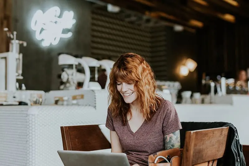 smiling woman looking at laptop