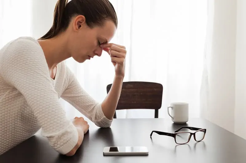 stressed woman sitting by the table