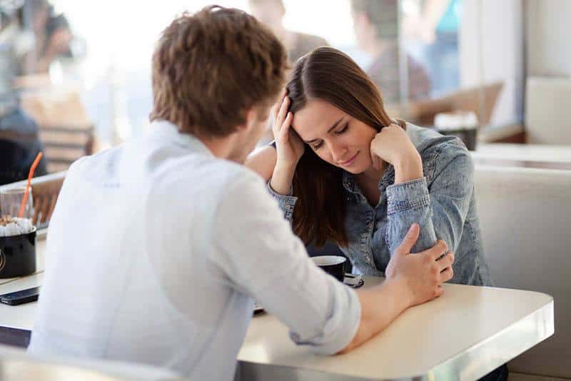 unhappy couple talking at cafe