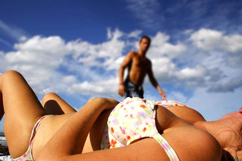 mujer en bikini tumbada en la playa