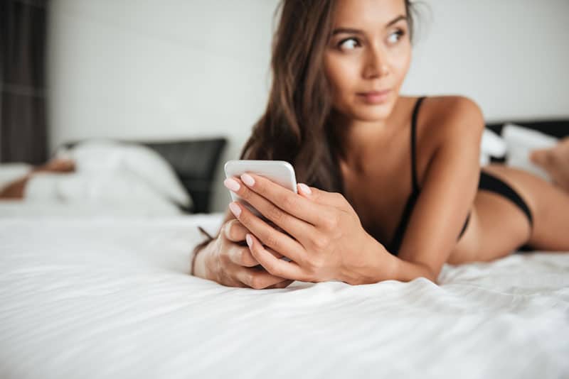 mujer en lenceria sosteniendo un telefono