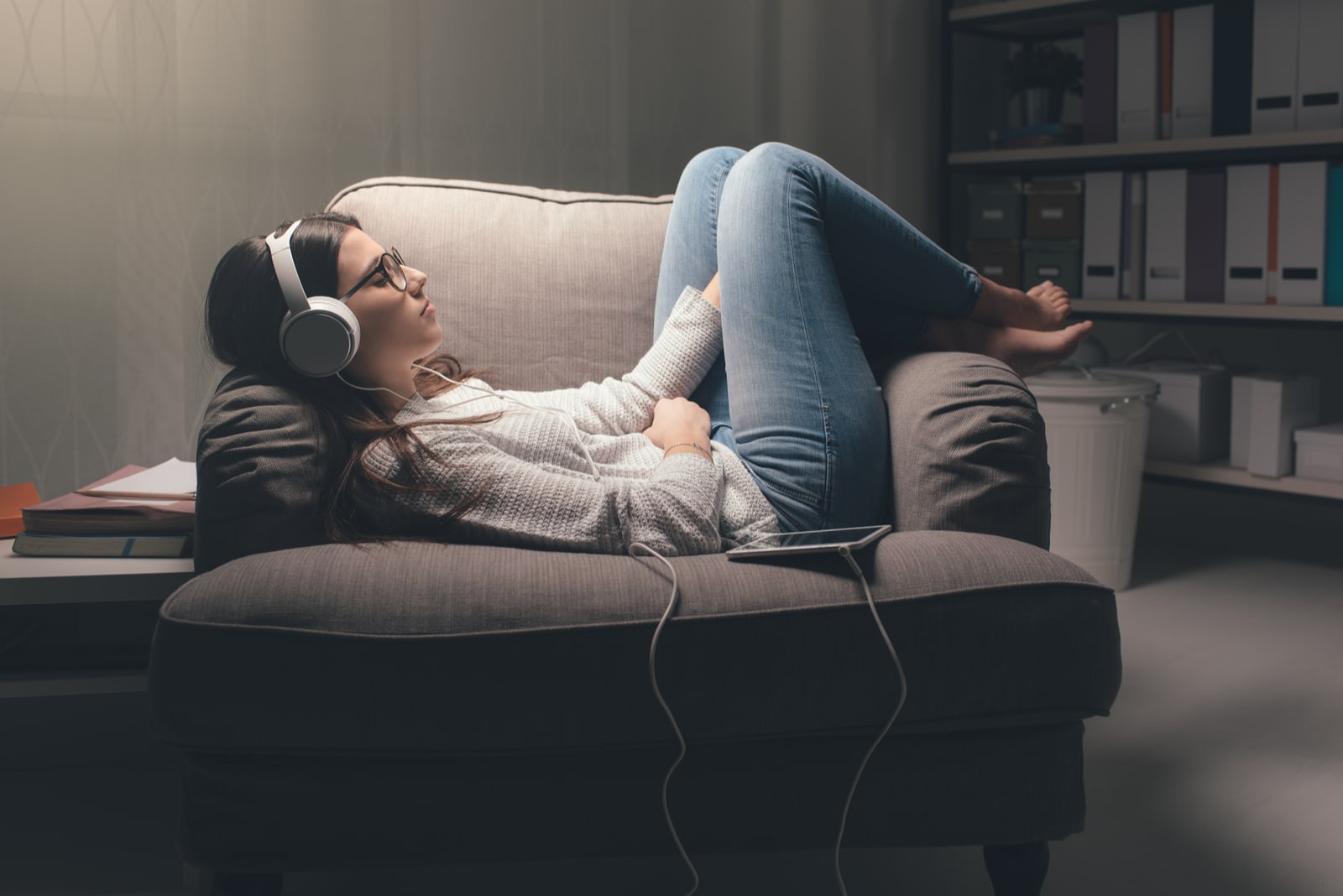 woman lying on sofa and listening music