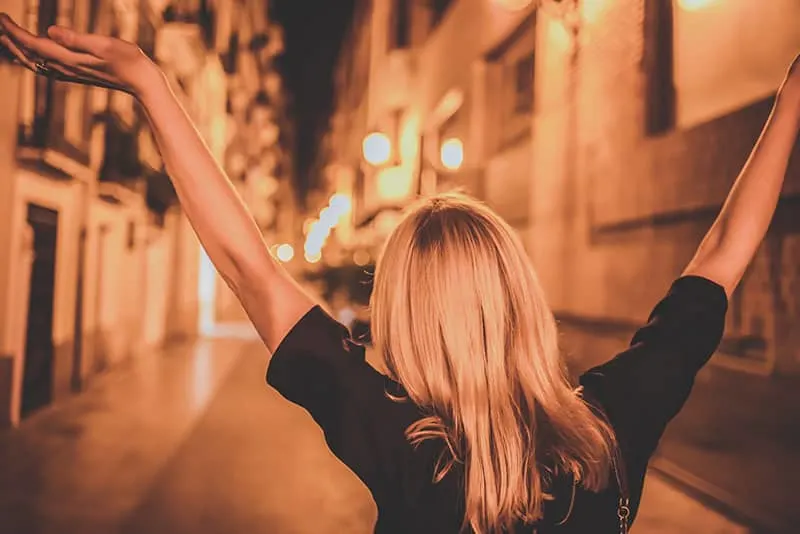 woman raising her hands in the air