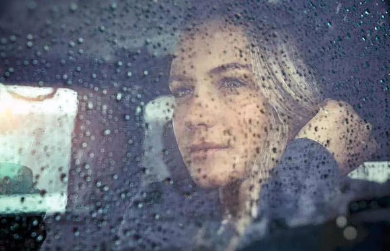 woman sitting in car during rain