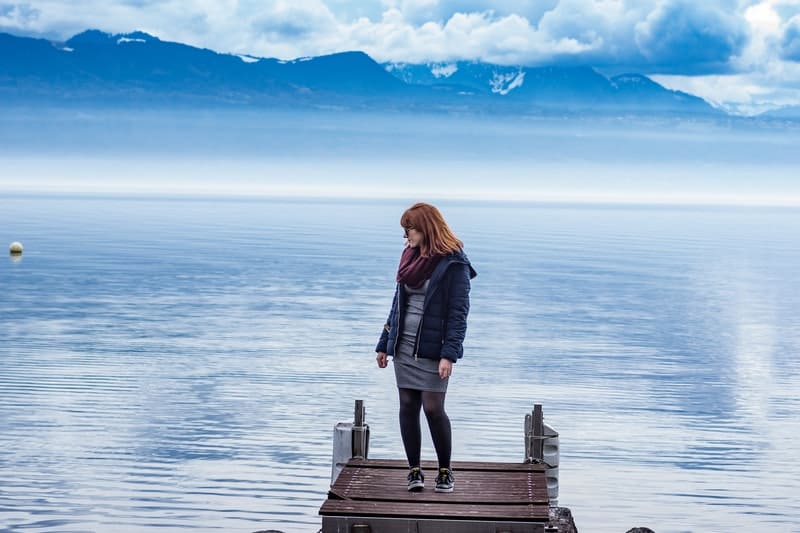 mujer de pie en la plataforma cerca del mar