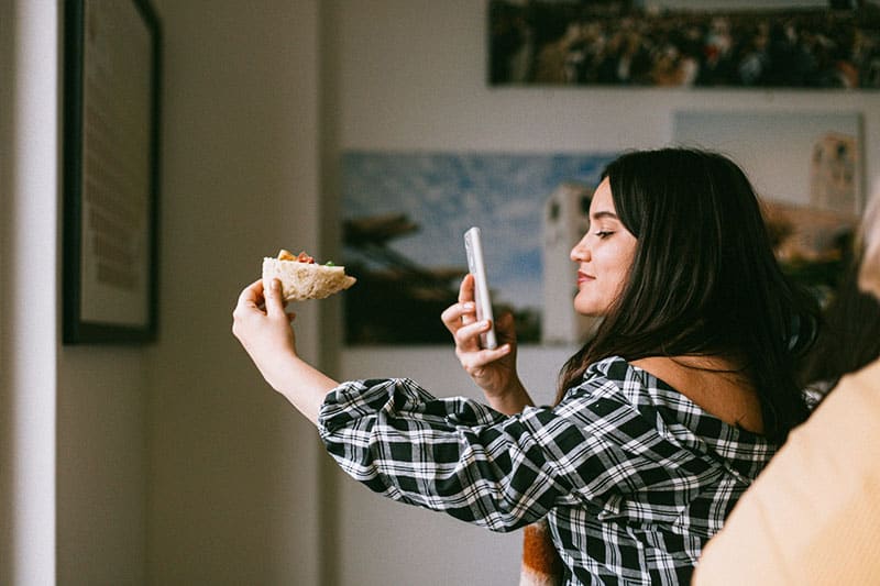 mujer fotografiando comida