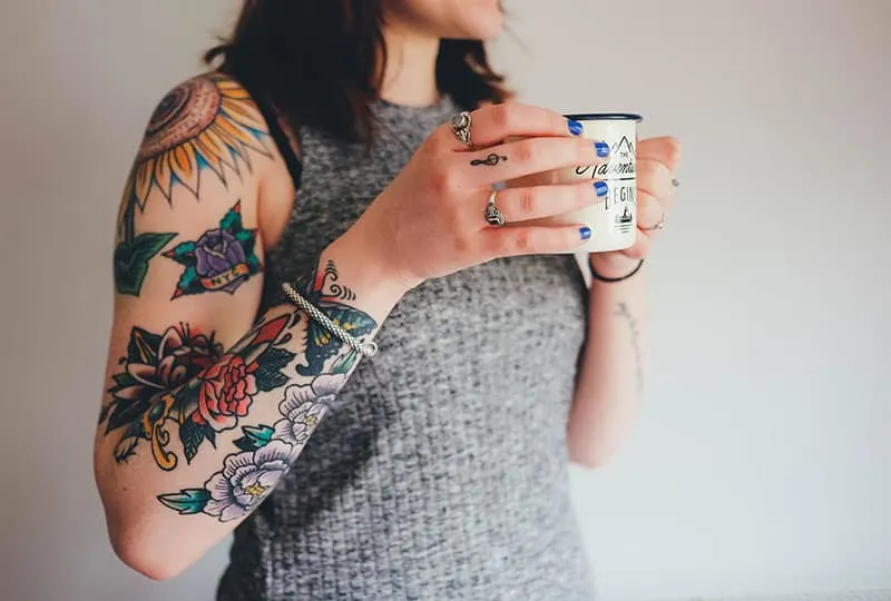 woman with colorful flower tattoos on her arm