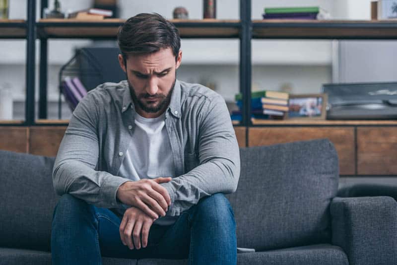worried man sitting on couch