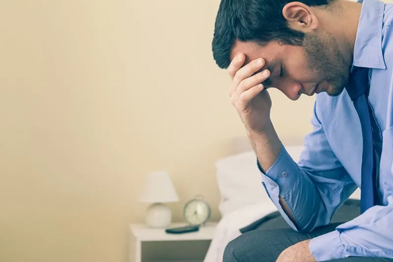 worried man sitting on the bed