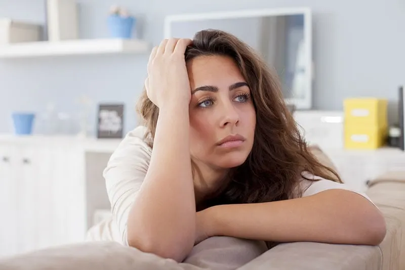 worried woman looking at distance in the living room
