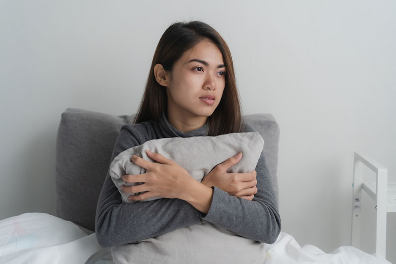 worried woman thinking in bed
