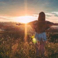 the woman stands with her arms outstretched