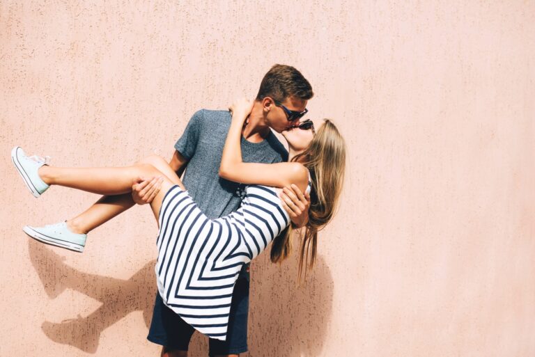 man kissing woman in arms