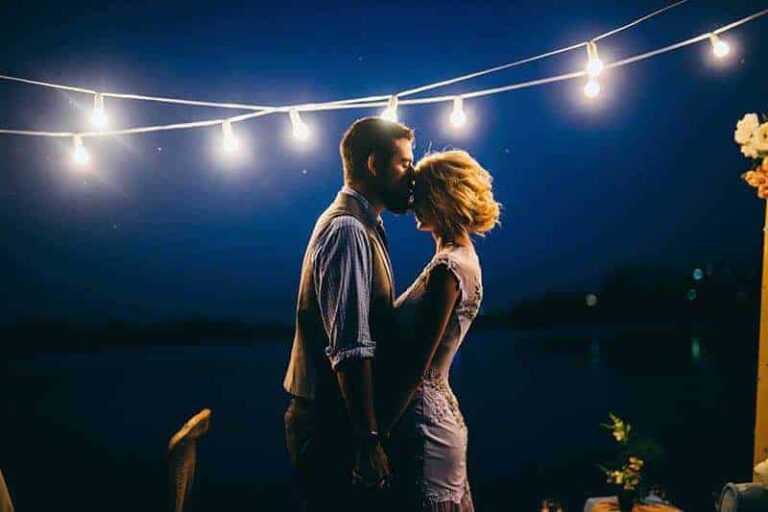 side view of groom kisses bride forehead
