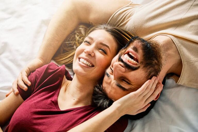happy couple laughing in the bed